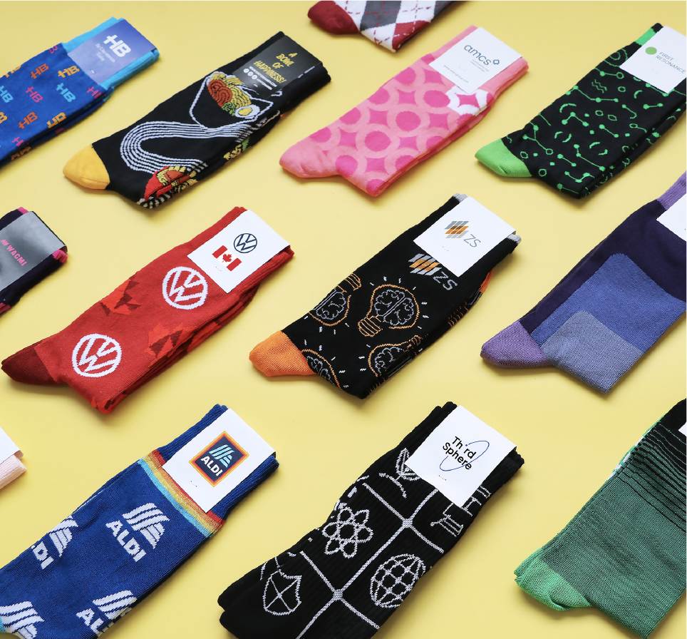 Custom branded socks laid out on a yellow background